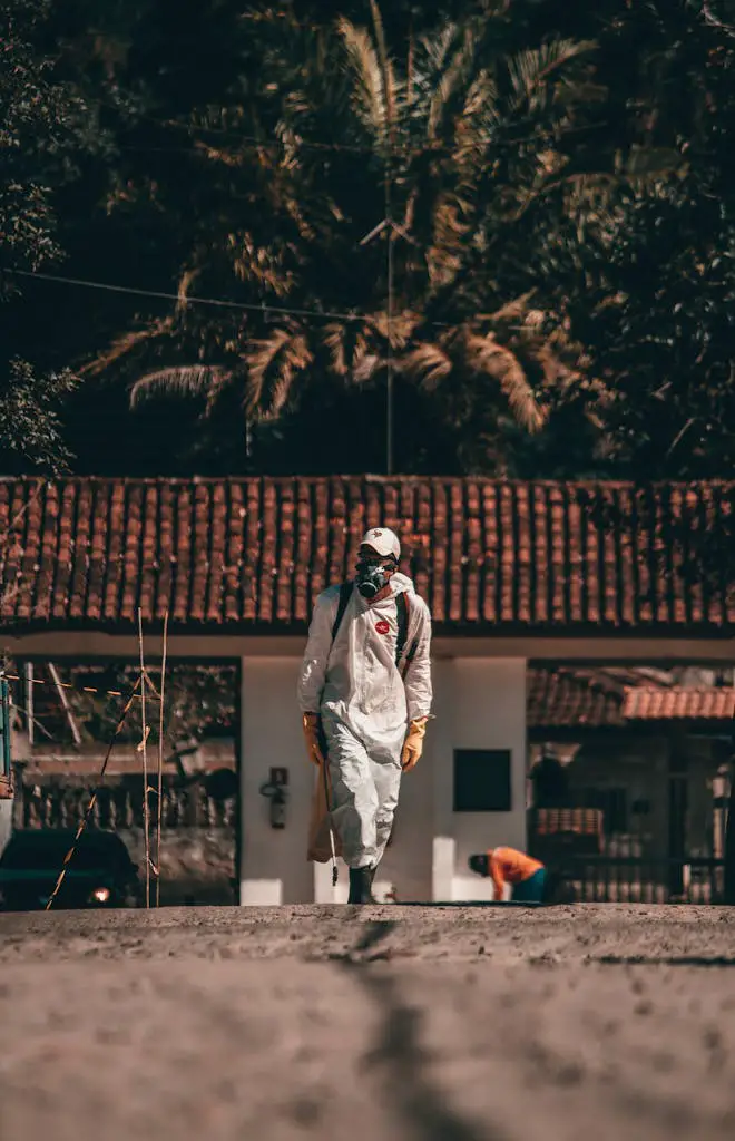 Full body anonymous person in protective hazardous materials suit and respirator walking in rural area in tropical country during coronavirus epidemic